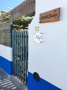 a sign that reads little smile next to a fence at Little Suite in Comporta