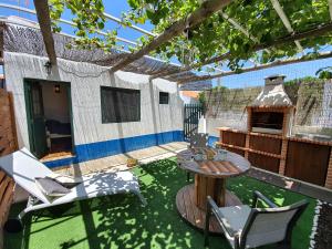 a patio with a table and chairs and a grill at Little Suite in Comporta