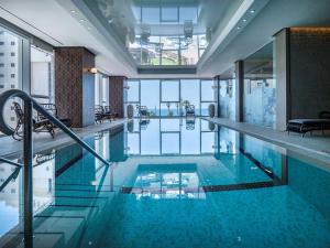 a large swimming pool in a building with blue water at David Tower Hotel Netanya by Prima Hotels - 16 Plus in Netanya