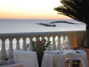 a table with a view of the ocean and a boat at GH Palazzo Suite & SPA in Livorno