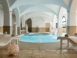 a large pool with a water slide in a building at Borgobianco Resort & Spa Polignano - MGallery Collection in Polignano a Mare