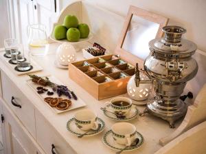 a counter with cups and saucers and a box of cookies at Borgobianco Resort & Spa Polignano - MGallery Collection in Polignano a Mare