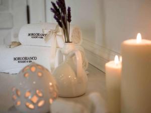 a table with two candles and a vase with flowers at Borgobianco Resort & Spa Polignano - MGallery Collection in Polignano a Mare
