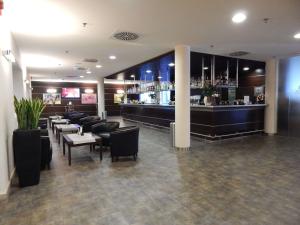 a restaurant with a bar with tables and chairs at Mercure Leonardo da Vinci Rome Airport in Fiumicino