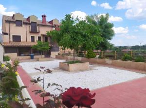 un patio frente a una casa con un árbol en Apartamento Los Callejones en Las Majadas