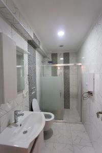 een badkamer met een toilet, een wastafel en een douche bij Alpha Rezidans Braslaw dom in Fethiye