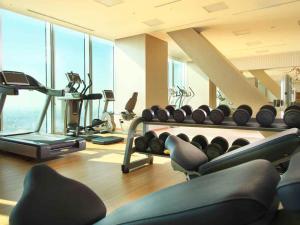 a gym with a bunch of treadmills and machines at Osaka Marriott Miyako Hotel in Osaka