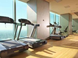 a gym with several cardio machines in a room with windows at Osaka Marriott Miyako Hotel in Osaka