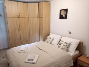 een slaapkamer met een bed met handdoeken erop bij apartman Emili in Malinska
