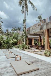 un complejo con un montón de colchonetas de meditación en una terraza de madera en Surfing Temple Hotel Boutique en General Luna