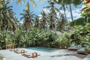 a resort with a swimming pool and palm trees at Surfing Temple Boutique Hotel in General Luna