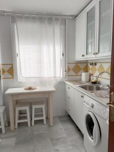 a white kitchen with a sink and a washing machine at Apartamento Nao Victoria in Sanlúcar de Barrameda