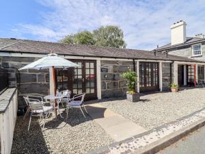 a patio with a table and chairs and an umbrella at Maritime Mews, 6 The Oakleys in Porthmadog