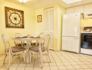 a kitchen with a table and chairs and a refrigerator at Siesta Palms By the Beach in Sarasota