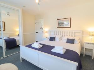 a bedroom with a large white bed and a mirror at Sea View apartment in Porthmadog