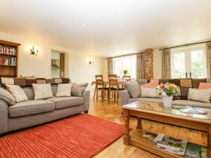 a living room with couches and a table at Belview Cottage in Sturminster Newton