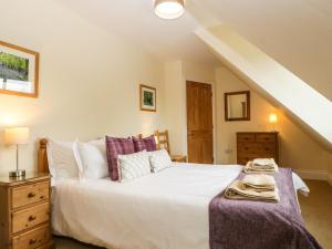 een slaapkamer met een groot wit bed en een trap bij Belview Cottage in Sturminster Newton