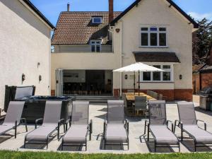 a patio with chairs and a table and an umbrella at Greenlawns in Burnham on Sea