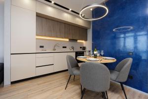 a kitchen with a table and chairs in a room at Level 24 - Sea & Sky View Apartment in Odesa