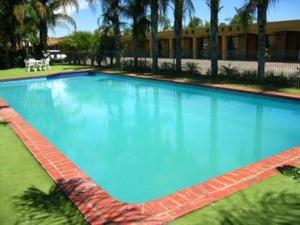 a large blue swimming pool in front of a building at The Edge Motel in Buronga