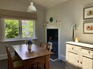 Country Bliss Cottage في غريتاون: غرفة طعام مع طاولة خشبية ونافذة