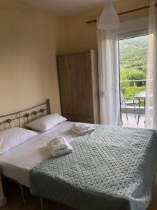 1 dormitorio con 1 cama con 2 toallas en Sofia' s Beach House, en Toroni