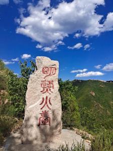 una roca con escritura delante de una montaña en Air Cloud Guesthouse en Huailai