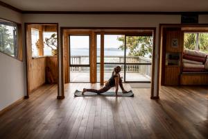 a woman doing a yoga pose on the floor of a house at Solscape in Raglan