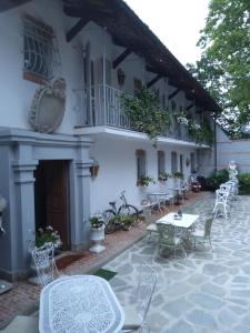 un patio con mesas y sillas frente a un edificio en ANTICA VILLA - Guest House & Hammam - Servizi come un Hotel a Cuneo en Cuneo