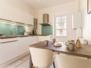 a kitchen with white cabinets and a wooden table with chairs at Gîte Saint-Brevin-les-Pins, 3 pièces, 4 personnes - FR-1-306-1206 in Saint-Brevin-les-Pins