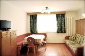 a living room with a table and a couch at Apartments Bracun in Corvara in Badia