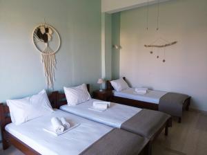 a room with two beds and a mirror at Alcyon days in Agios Georgios