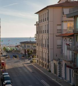 una via cittadina con edifici e l'oceano sullo sfondo di Casa Arsella a Viareggio