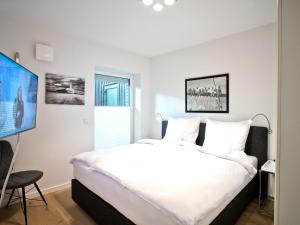 ein Schlafzimmer mit einem großen Bett und einem Flachbild-TV in der Unterkunft Landhaus Lueneburg Komfort Apartment in Lüneburg