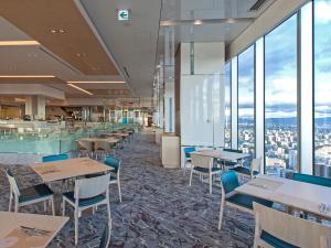 a restaurant with tables and chairs and windows at Osaka Marriott Miyako Hotel in Osaka