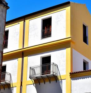ein gelbes und weißes Gebäude mit 2 Balkonen in der Unterkunft Alla Loggia Del Gattopardo in Palermo