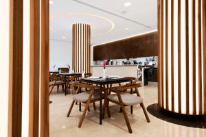 a dining room with tables and chairs in a restaurant at Horizon Hotel in Al Başrah