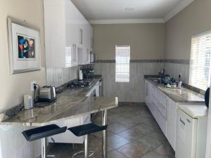 a large kitchen with a counter and chairs in it at The Fox Hole in Krugersdorp