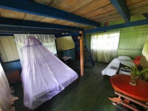 a room with a bed and a table in a room at Cabañas alto del aguila in Puerto Nariño