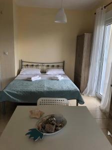 um quarto com uma cama com um prato de comida numa mesa em Sofia' s Beach House em Torone