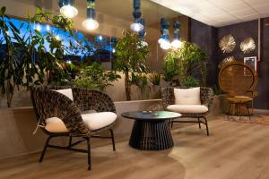 a living room filled with furniture and plants at Aemilia Hotel Bologna in Bologna