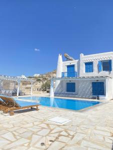 uma casa com uma piscina em frente em Blue Harmony Suites of Mykonos em Míconos