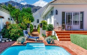 einen Hinterhof mit einem Pool und einem Haus in der Unterkunft Bleu Cobalt Cottage in Franschhoek