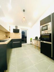 a kitchen with black cabinets and a stove top oven at Apartma Teja-Dekani in Dekani
