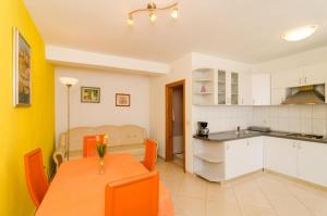 a kitchen and dining room with a table and chairs at Apartments Plavac Mali in Potomje