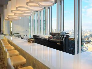 a restaurant with a bar with a view of the city at Osaka Marriott Miyako Hotel in Osaka