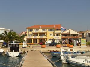 a group of boats docked at a dock in a marina at BUCO seafront apartments & fastfood in Pakoštane