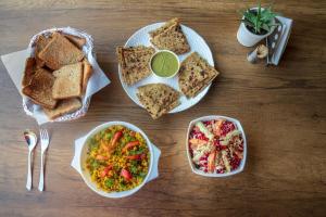 a wooden table topped with plates of food and toast at H7Stay Luxury Cottages And Camps, Rishikesh in Rishīkesh
