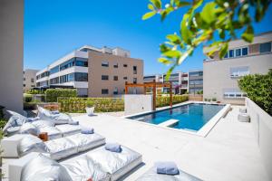 Un patio con piscina y tumbonas y una piscina. en Ika Boutique Luxury Apartments, en Zadar
