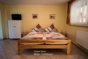 een slaapkamer met een houten bed en een tv aan de muur bij Hohlfeld´s Ferienwohnung in Bad Schandau